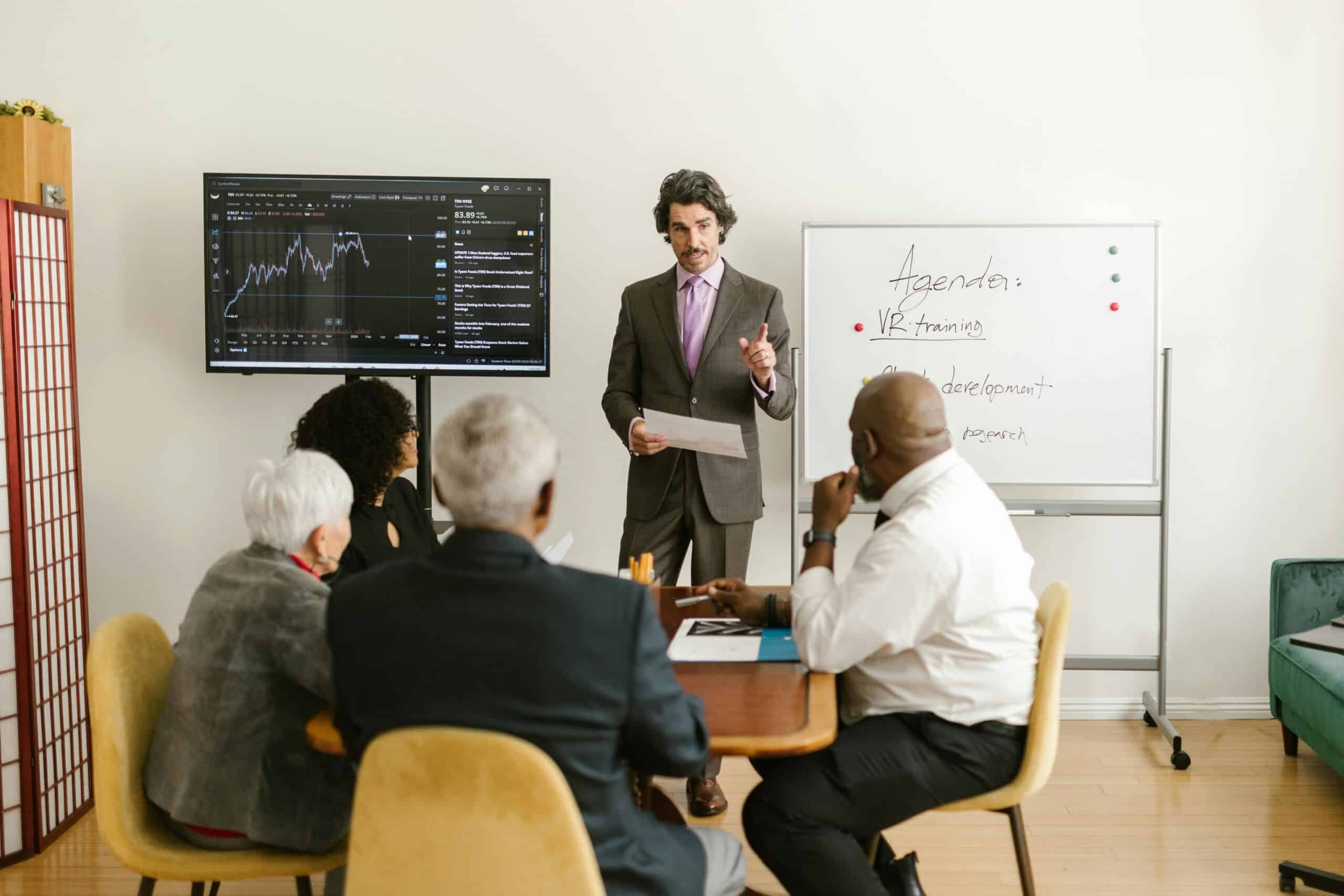 Business meeting with diverse professionals discussing data and strategies in a modern conference ro.