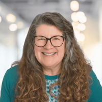 Professional portrait of a smiling woman with glasses at Canyon GBS.