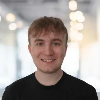 Friendly young man smiling in modern office environment.