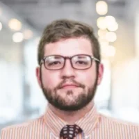 Professional man with glasses in a modern office setting.