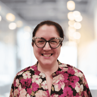 Woman smiling in business attire at Canyon GBS office environment.
