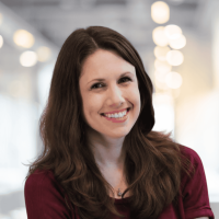 Confident woman smiling in a modern office environment, representing professionalism and success.