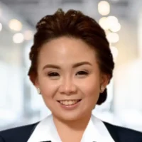 Businesswoman smiling in professional attire, indoor office background, confident and approachable.