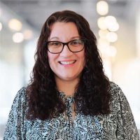 Office woman wearing glasses at Canyon GBS, smiling confidently.