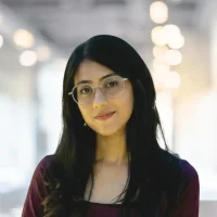 Professional woman with glasses in a modern office setting.