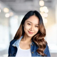 Young woman smiling in a bright, modern office environment, representing professional success.
