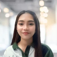 Customer service representative smiling in a modern office environment.